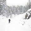 Backcountry skier walks in a snowy mountain valley
